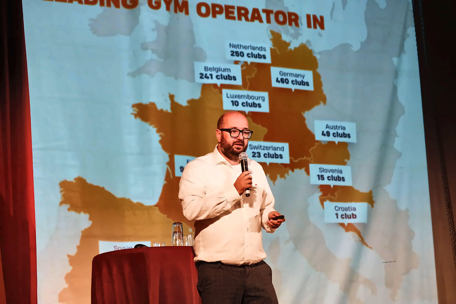 Adriaan Bos of Basic-Fit speaking in front of a map of Basic-Fit clubs in Europe